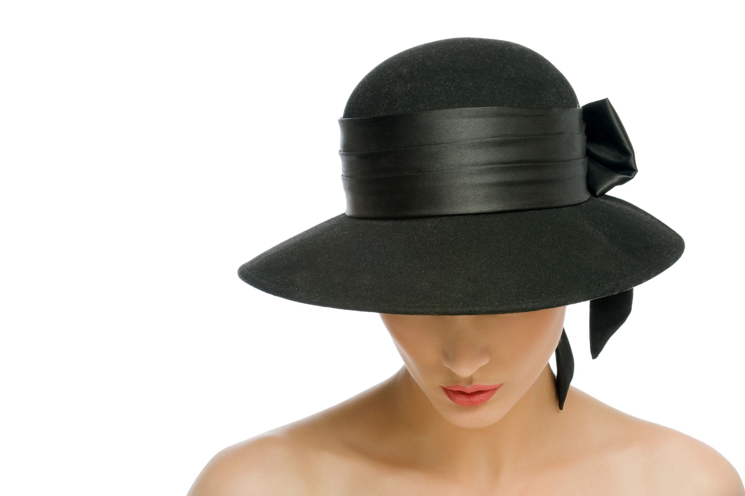 Woman in a stylish black wide-brimmed hat with a ribbon bow.