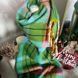 Cozy green plaid blanket with a festive "Merry Christmas" sign.